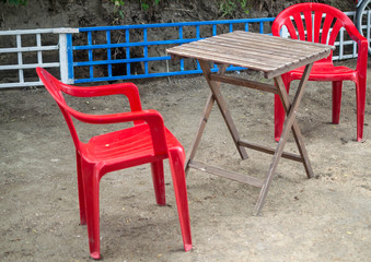 wooden table plastic chairs on the ground