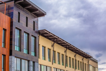 Obraz premium Building exterior with a flat roof against sky covered with puffy gray clouds