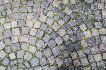 Top view of a cobblestone road. Abstract summer background of old circular pattern pavement
