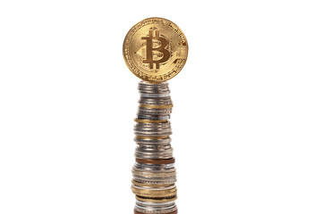 Bitcoin at the top of a coin pyramid from different countries on a white isolated background
