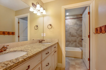 Bathroom interior with a double vanity unit and hanging racks on the wall
