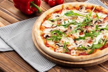 Italian Delicious Fresh Hot Mix Baked Pizza with Melting Cheese, sliced mushrooms , tomato sauce and cheddar serving on textured rustic background. Mushrooms pizza. top view.