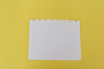 School notebook on a yellow background. Back to school concept, top view, copy space