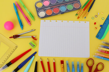 Naklejka premium sheet from school notebook and colored various stationery. Back to school concept, top view, paints, pencils, pens, copy space