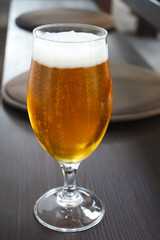 Closeup of a glass of light beer on the bar, summer vacation concept, selective focus