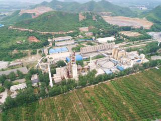 Fototapeta na wymiar Aerial view of dusty factory with mountain on the background, Huaibei, China. industrial pollution