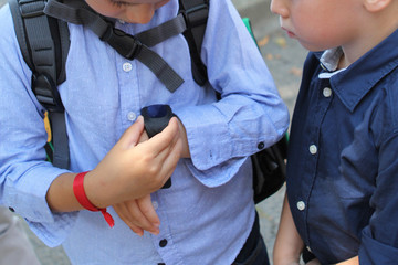 boy shows another child a smart watch with a GPS TRACKER