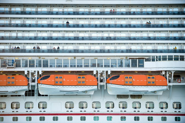 Full frame travel background of towering cruise ship with life boats