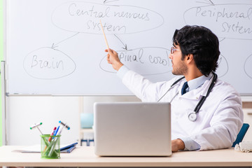 Young male doctor neurologist in front of whiteboard 