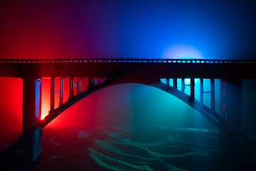 Artwork decoration. Silhouette of powerful metallic bridge at night with foggy backlight. Silhouette of person standing on bridge.