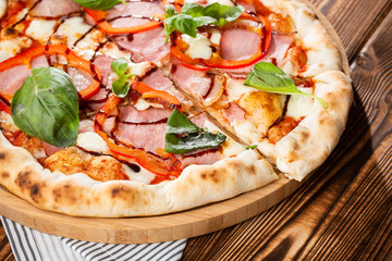 Pizza on wooden background, top view. Pizza with pepper, ham,  Basil and Mozzarella Cheese close up. Flyer and poster for Restaurants or pizzerias, template with delicious taste  pizza.