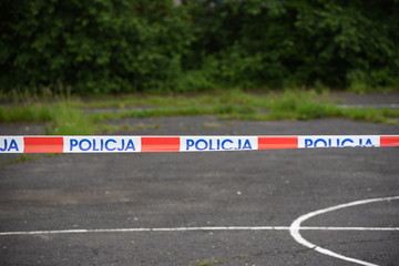 The symbol of the Polish Police on the tape separating the crime scene