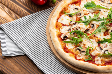 Italian Delicious Fresh Hot Mix Baked Pizza with Melting Cheese, sliced mushrooms , tomato sauce and cheddar serving on textured rustic background. Mushrooms pizza. top view.