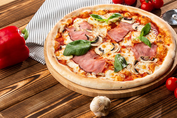 Italian Delicious Fresh Hot Mix Baked Pizza with Melting Cheese, sliced mushrooms , ham, tomato sauce and cheddar serving on textured rustic background. top view.