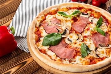 Italian Delicious Fresh Hot Mix Baked Pizza with Melting Cheese, sliced mushrooms , ham, tomato sauce and cheddar serving on textured rustic background. top view.