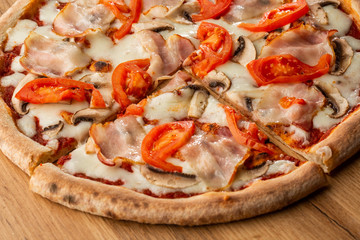 Italian Delicious Fresh Hot Mix Baked Pizza with Melting Cheese, sliced mushrooms , ham, tomato sauce and cheddar serving on textured rustic background. top view.