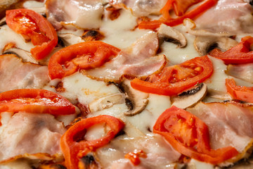 Italian Delicious Fresh Hot Mix Baked Pizza with Melting Cheese, sliced mushrooms , ham, tomato sauce and cheddar serving on textured rustic background. top view.