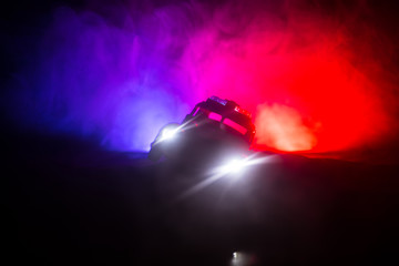 Police cars at night. Police car chasing a car at night with fog background. 911 Emergency response