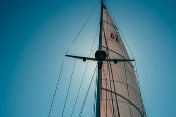 Looking up towards Sailboat Sails with the Bright sun shining through
