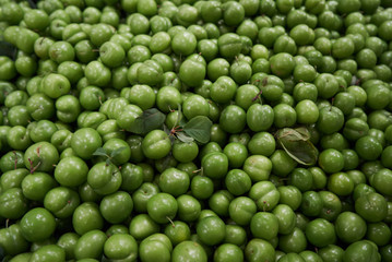 Green cherry plum fruit food background, top view.