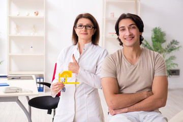Female doctor checking patient's joint flexibility with goniometer