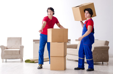 Two young contractor employees moving personal belongings