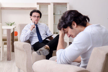 Young male patient discussing with psychologist personal problem