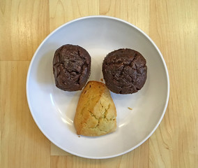 Three pieces of pastry arranged on a white plate to look like a funny face