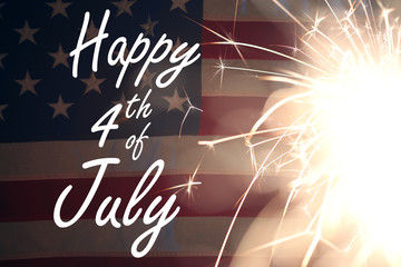 Lit sparkler burning in front of American Flag
