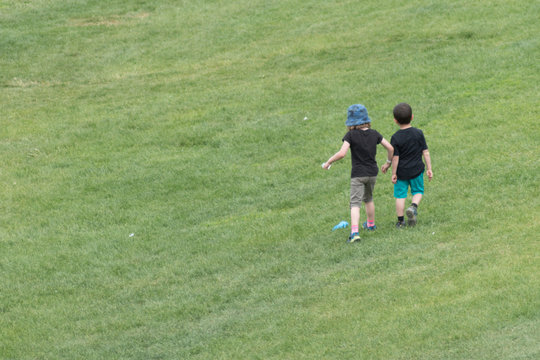 Two kids playing in a lush green garden 