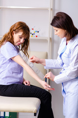 Obraz premium Female doctor checking patient's joint flexibility with goniomet
