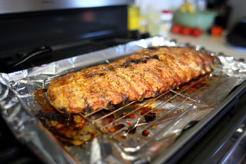 Rack of St. Louis cut style ribs resting in a baking tray on the stove top.