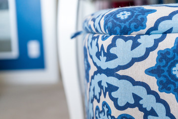 Close up of a blue and white fabric laundry basket (a decorative storage box with a lid), in a bedroom with blue and white interior decor. Selective focus on the laundry hamper.
