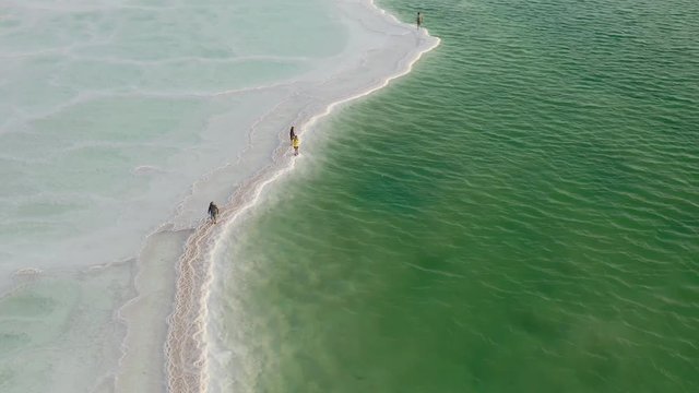 Distant shot of people at the dead sea in Israel, aerial 4k sunny morning