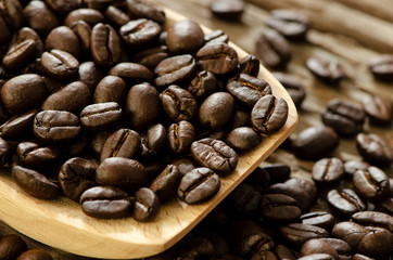 Close up the coffee seeds in the wooden spoon
