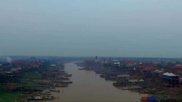 view of  pull back over the river, pan down on fishermen nets. Tonle sap, mekong river. Pile of boats parked on the river.