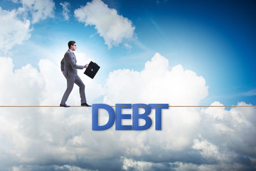 Debt and loan concept with businessman walking on tight rope