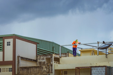 Worker welding the steel part for roof  before it is going to rain.