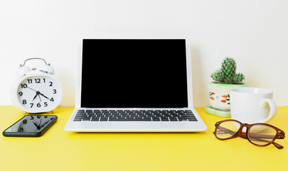 Laptop placed on a yellow table background of business working place with cup coffee, Empty workspace