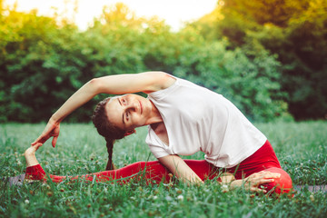 girl doing yoga outdoors on the grass