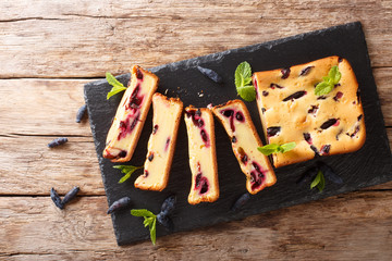 Berry cake with honeysuckle and mint on the board closeup on a table. horizontal top view from above