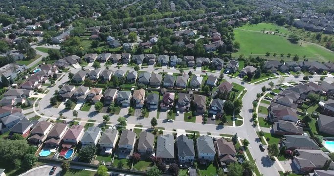 Descending Over Neighborhood With Lush Green Grass And Park In Upper Right Hand Corner