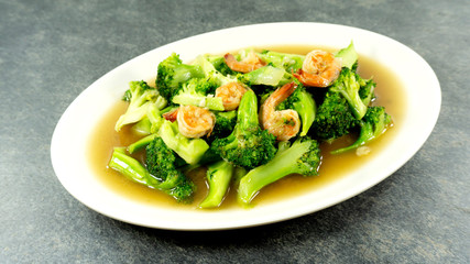 Thai food. Stir fried broccoli with shrimp on stone background. Top view, Copy space for design.