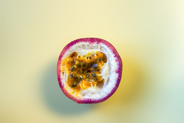 close up of a granadilla cut in hlaf on yellow background