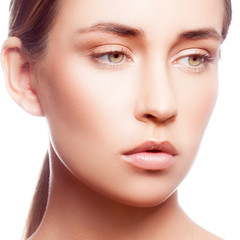 Fototapeta premium Pretty beauty face of young model girl, clean skin, nude makeup, natural lips, clean skin, green eyes. Sensual close-up portrait. Skincare facial treatment concept. White background 