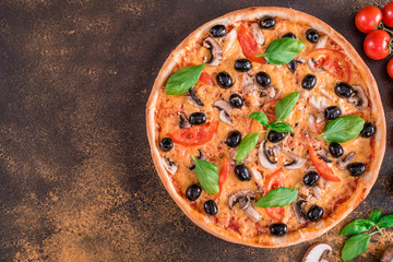 Tasty fresh hot pizza against a dark background. Pizza, food, vegetable, mushrooms.  It can be used as a background