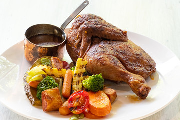 close up roast baked chicken with grilled vegetables