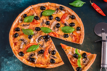 Tasty fresh hot pizza against a dark background. Pizza, food, vegetable, mushrooms.  It can be used as a background