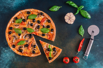 Tasty fresh hot pizza against a dark background. Pizza, food, vegetable, mushrooms.  It can be used as a background
