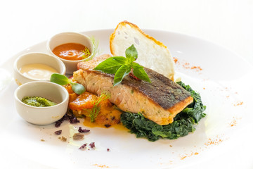 close up of grilled salmon with vegetable and sauce